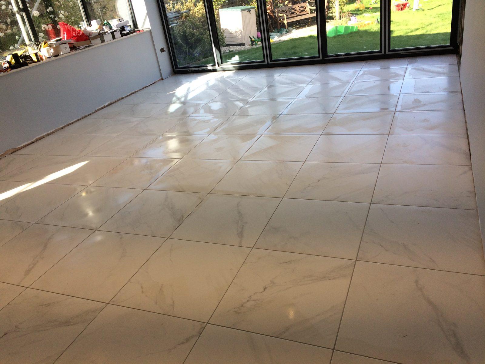 Polished marble-effect floor tiles in an open-plan room by DTC Services